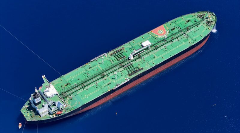 Aerial view of a large green oil tanker sailing in deep blue ocean water
