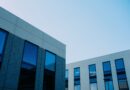 Modern commercial office buildings with reflective glass windows under a clear blue sky